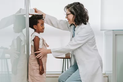 A Physician Checks Her Pediatric Patient's Height