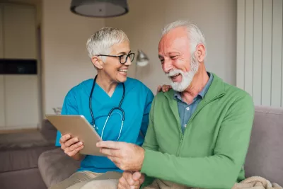 A Nurse Smiles as She Goes Over a Patient's Chart with Him