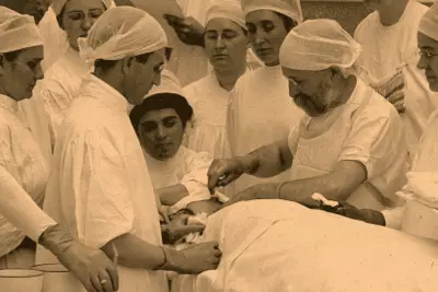Doctor performing surgery while students watch