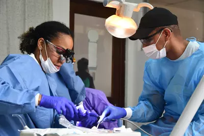 Two people provide dental care to a Guatemalan patient.