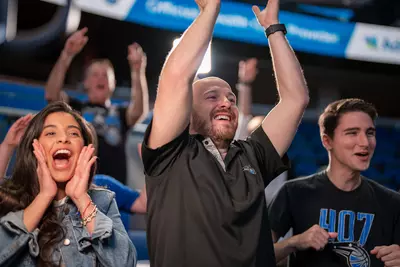 Fans cheering at an Orlando Magic game.
