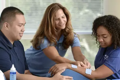 Three nurses going through a bandage training session