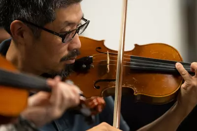 Dr. Vincent Hsu practices with the AdventHealth employee orchestra.