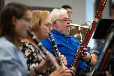 Ian Barnett, right, practices with the AdventHealth employee orchestra.