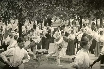 Old photograph of people balancing on one leg and stretching outdoors. 