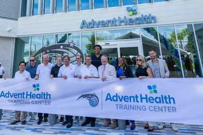 AdventHealth and Orlando Magic executives pose with Orlando Magic player, Wendell Carter Jr. in front of the new AdventHealth Training Center 