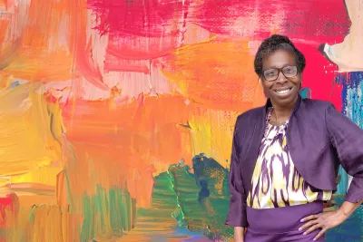 Denise Giles in front of a painterly background.