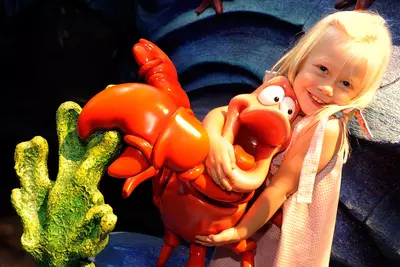 Girl hugging Sebastian the Crab at AdventHealth for Children