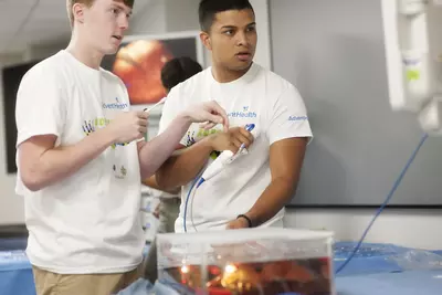 Two young men learning about robotic surgery