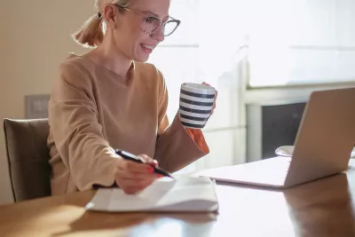 A woman on her computer and taking notes