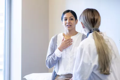 A young woman speaks to her female doctor.