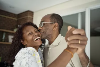 African American senior couple dancing on the balcony 