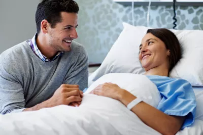 A couple holds hands while in the hospital.