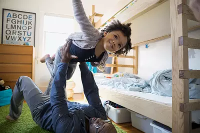 Child being held in the air with outstretched arms