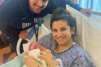 Photo of mom in the hospital holding her baby next to the dad