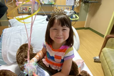 Faith Ahn smiles at the camera with balloons to celebrate leaving the hospital.