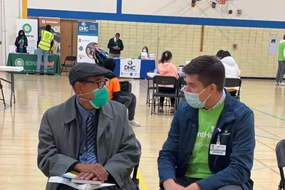 Man talking with a volunteer at a Chicago Mission Clinic location.