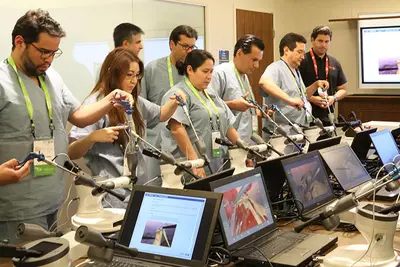 Professionals performing laparoscopic simulations in a Nicholson Center Lab Boardroom.