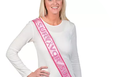 Woman wearing breast cancer survivor sash