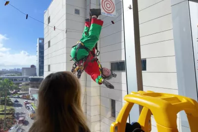 A deputy dressed as an elf rappels from the children's hospital roof to wave to patients inside.