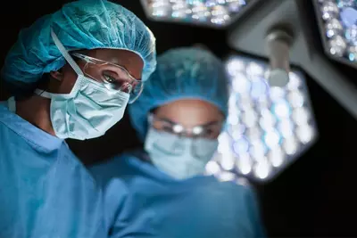 Two surgeons wearing masks in the operating room