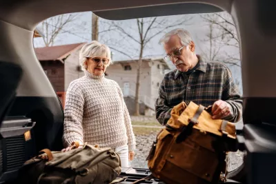 A senior couple packs their car to prepare for a hurricane.