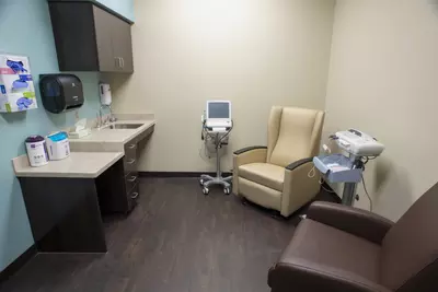 Room with medical equipment, chairs, and a desk