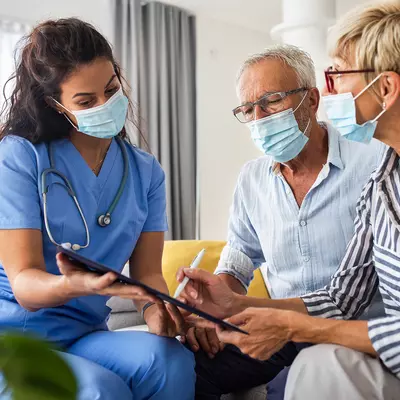 Nurse goes over information with a patient and their spouse.