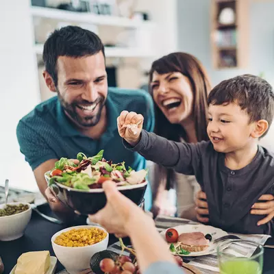  A Family Gathers Around The Kitchen Table To Enjoy Some Healthy Foods.