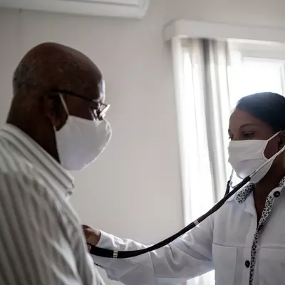 A doctor using a stethoscope on a patient