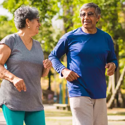 A mature couple exercising outdoors together.