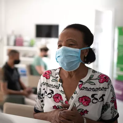 A woman visiting a medical provider wearing a mask.