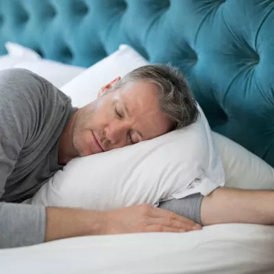 Man taking a nap in bed at home.