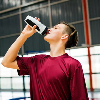 A woman drinking water after exercising.