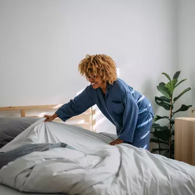 Woman making her bed in the morning.