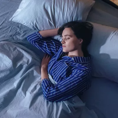 Woman sleeping on her side in bed.