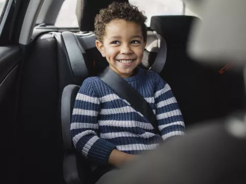 A little boy in a carseat.