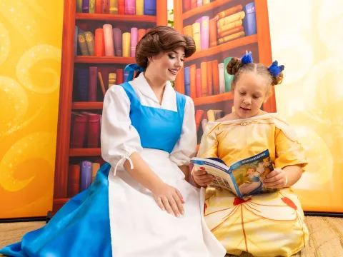 Disney Princess Belle reads with a young patient at AdventHealth for Children in Orlando.