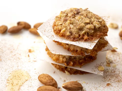 Four stacked almond-maple cookies with almond garnish