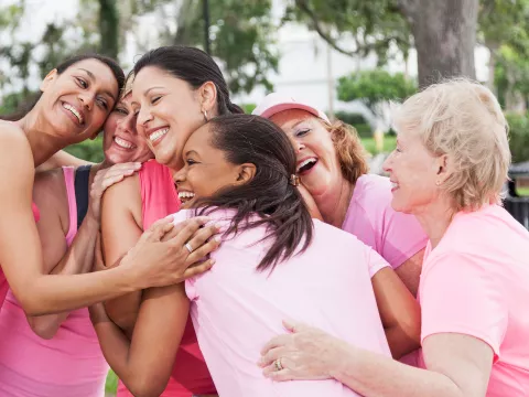 women wearing pink shirts and hugging