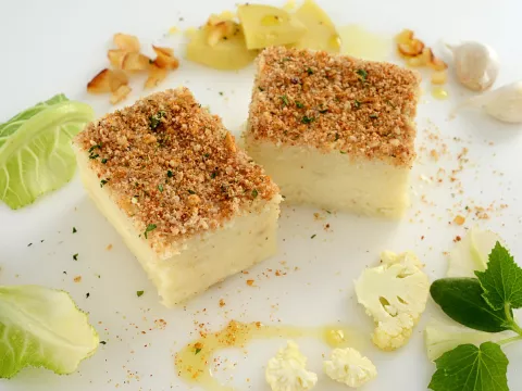 Pureed cauliflower molded into a cube with a crispy breadcrumb topping