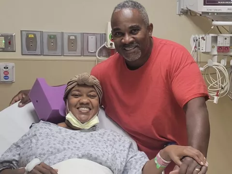 Charlie Simmons in the hospital with her husband by her side