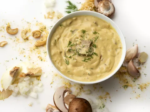 Bowl of stroganoff with cashew and mushroom garnishes