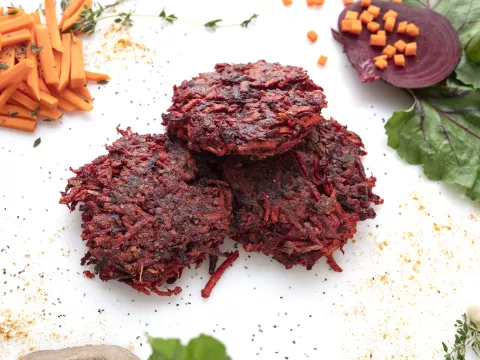 Three shredded-beet patties with carrot stick garnish