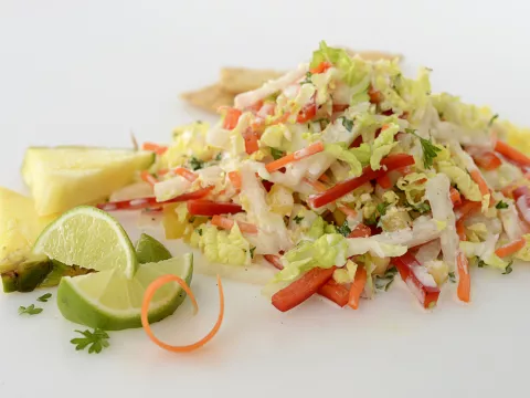 Mound of slaw with lime and pineapple wedges