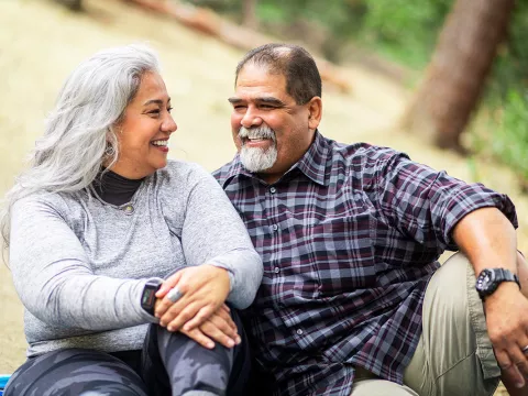 A Hispanic couple sitting at the park