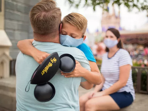 Son hugging dad after Dad telling him he is going to be a big brother.