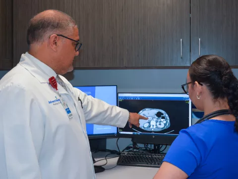 Dr. Norbert Garcia-Henriquez analyzes a patients scan with a team member at the AdventHealth Cancer Institute.