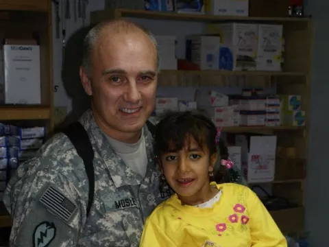 Dr. E. Wayne Mosley served seven tours in Afghanistan and Iraq as a combat physician with the U.S. Army. He's pictured here with a young patient in Mosul, Iraq. Photo Courtesy of Dr. E. Wayne Mosley