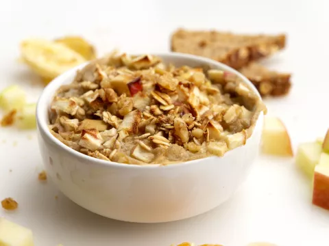 Bowl of cooked apples and oat with apple chunk garnish